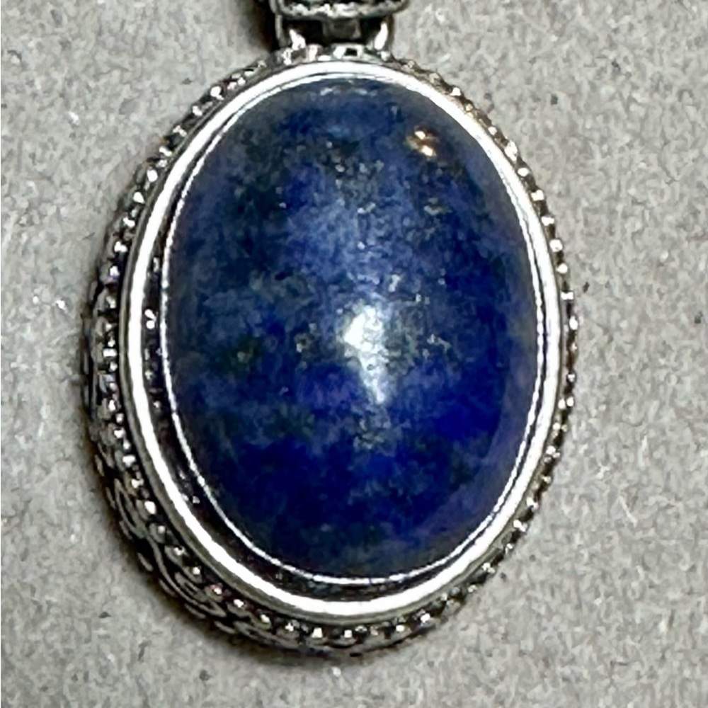 Lapis Lazuli Blue and Silver Pendant putting it up to show someone.
